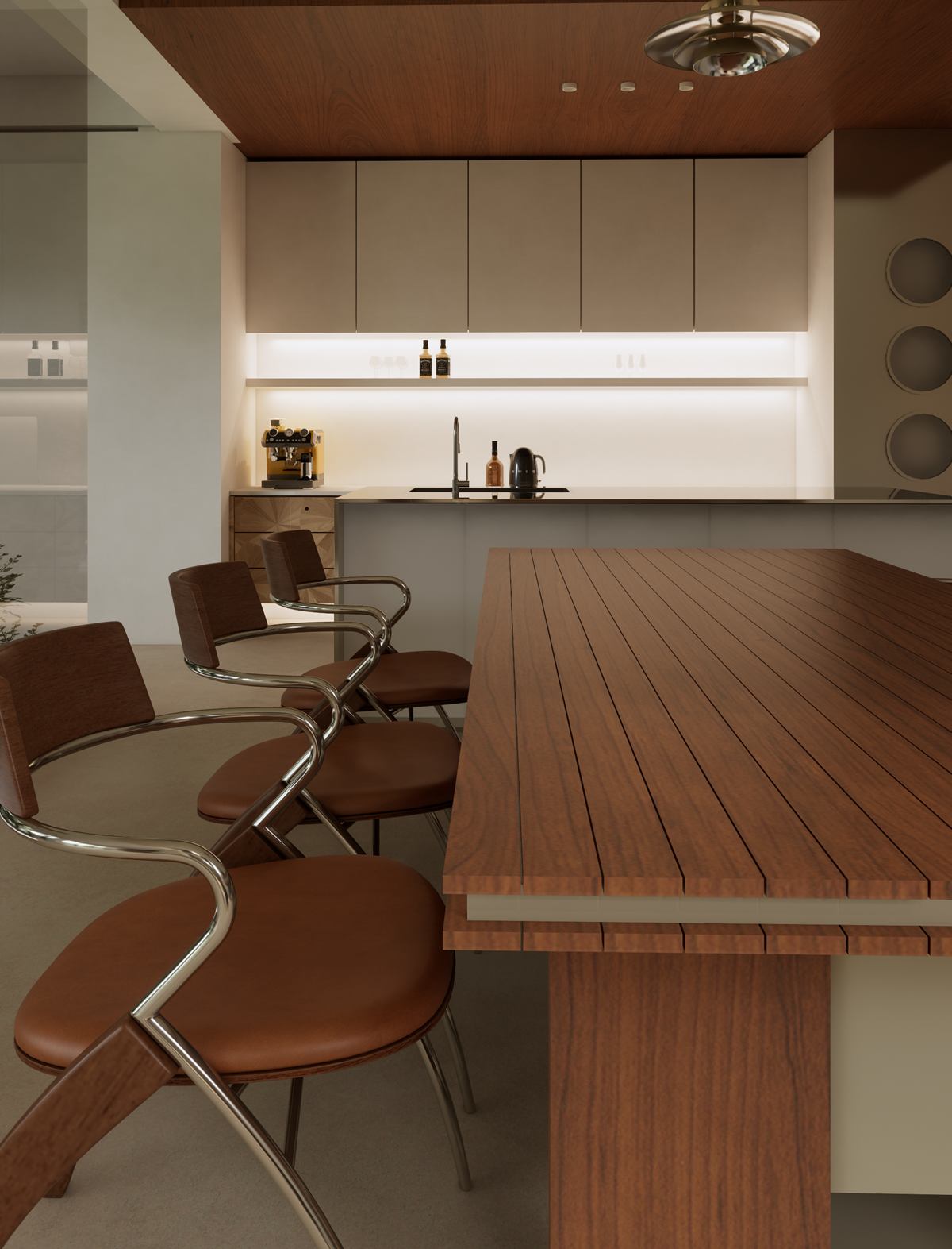 A timber-topped island with curved leather and chrome stools, in front of pale kitchen cabinets.